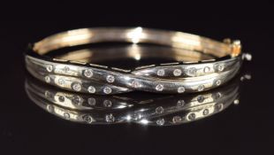 A 9ct gold bangle set with diamonds, the total diamond weight approximately 0.5ct, in a twisted