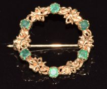 A 9ct gold circular brooch set with emeralds, 2.3g, 2cm