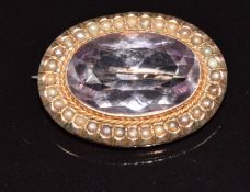 A 9ct rose gold brooch set with an oval cut amethyst surrounded by seed pearls, 6.1g, 3 x 2.2cm
