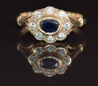 A 9ct gold ring set with an oval cut sapphire surrounded by diamonds, 2.7g, size L