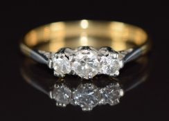An 18ct gold ring set with three diamonds in a platinum setting, the centre diamond approximately