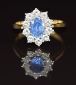An 18ct gold ring set with an oval cut sapphire of approximately 1.4ct surrounded by diamonds,