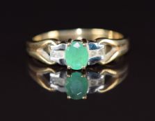 A 9ct gold ring set with an oval cut emerald of approximately 0.25ct and diamonds, 2g, size J