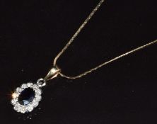 A 9ct gold pendant set with an oval cut sapphire approximately 0.5ct surrounded by diamonds, on