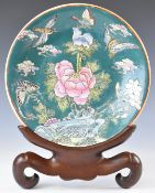 Chinese charger decorated with flora and fauna, and with six character mark to base, on a hardwood