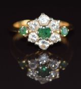 An 18ct gold ring set with three emeralds, the centre emerald approximately 0.3ct and diamonds, each