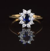 A 9ct gold and silver ring set with a synthetic oval sapphire surrounded by cubic zirconia, 1.8g,