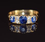 A c1910 18ct gold ring set with three oval cut sapphires, the centre sapphire approximately 0.45ct