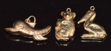Three 9ct gold charms in the form of a koala bear, dolphin and pelican, 2.4g