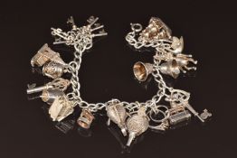 Silver charm bracelet with 16 silver charms including boat, ski lift, fish opening to reveal a