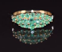 A 9ct gold ring set with round cut emeralds and two diamonds, 2.6g, size P