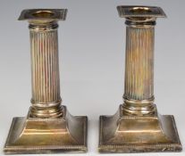 Pair of Edward VII hallmarked silver candlesticks with reeded columns, on square bases with beaded