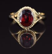 A 9ct gold ring set with an oval cut garnet, 2.3g, size L