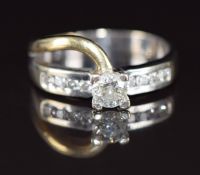 An 18ct gold bi-coloured ring set with a round cut diamond of approximately 0.4ct and further