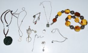 A collection of silver jewellery including an amber and silver necklace, chains and pendants,