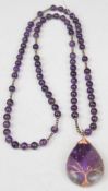 An amethyst beaded necklace with a fluorite pendant
