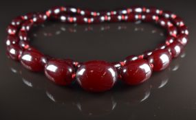 Cherry amber necklace made up of 44 graduated oval beads, largest 2.2 x 3cm, smallest 1.3 x 0.7cm,
