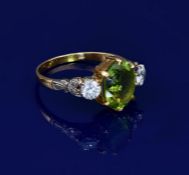 An 18ct gold ring set with an oval cut peridot of approximately 2.8ct and two diamonds, each