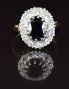 A 9ct gold ring set with an oval cut sapphire of approximately 1.8ct surrounded by diamonds, 3.9g,