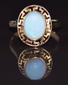A 9k gold ring set with an opal within a Greek key border, 2.7g, size L
