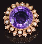 A c1900 9ct gold pendant/ brooch set with an round cut amethyst of approximately 25ct surrounded
