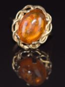 A 9ct gold ring set with a pressed amber cabochon, 2.5g, size K/L