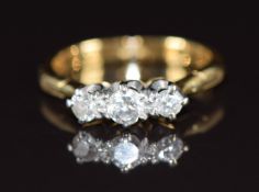 An 18ct gold ring set with three diamonds, the largest diamond approximately 0.16ct, with expandable