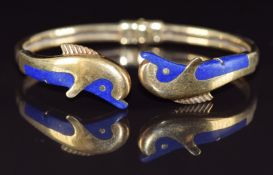 An 18ct gold bangle in the form of two dolphins set with lapis lazuli, 22.3g, 6 x 4.8cm