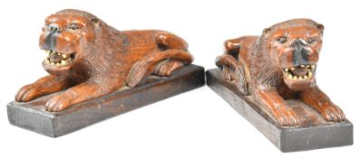 Pair of carved oak lions with bone teeth, length 24cm
