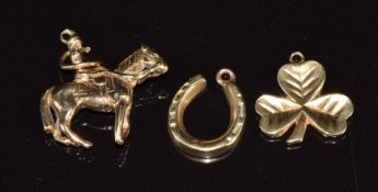 Three 9ct gold charms / pendants in the form of a lady riding a horse, horseshoe, and a shamrock, 5g