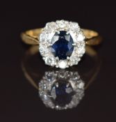 An 18ct gold ring set with an oval cut sapphire of approximately 1ct surrounded by diamonds in a
