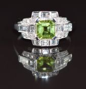 An 18k white gold ring set with an Asscher cut peridot of approximately 1ct and round and baguette