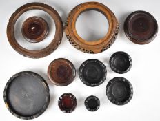 Eleven Chinese carved hardwood stands, the largest diameter 21cm