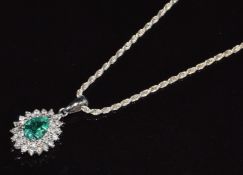 An 18k white gold pendant set with a pear cut emerald of approximately 0.6ct surrounded by thirty-