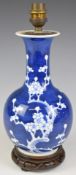 Chinese vase converted to a lamp with blue and white prunus decoration, raised on carved wooden
