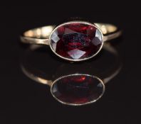 A 9ct gold ring set with an oval cut garnet, 1.7g, size K