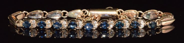 A 14k gold bracelet set with nine oval cut sapphires, each approximately 0.2ct and diamonds, 12.