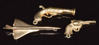 Two 9ct gold charms in the form of guns and a 9ct gold charm in the form of Concorde, 3.9g