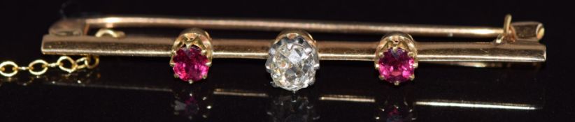 A 15ct gold brooch set with an old cut diamond of approximately 0.3ct and two rubies each