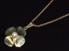 A 9ct gold pendant in the form of a four leaf clover (2cm) set with a pearl on on 9ct gold chain,
