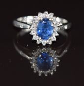 An 18ct white gold set with an oval cut sapphire of approximately 0.6ct surrounded by diamonds, with