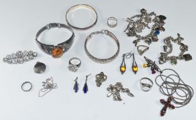 A collection of silver jewellery including pressed amber bracelet, bangle, two bracelets, two