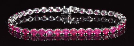 An 18k white gold bracelet set with 38 oval cut rubies, totalling approximately 10.2ct, 10g, 18cm