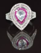 A 9ct gold ring set with a pear shaped rose cut diamond surrounded by calibre cut rubies and further