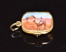 Egyptian Revival charm set with enamel depicting a camel and pyramid opening to reveal a miniature