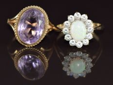 A 9ct gold ring set with an oval cut amethyst and a 9ct gold ring set with an opal cabochon