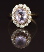 A 9ct gold ring set with an oval cut amethyst surrounded by paste, 3.8g, size R