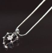 An 18ct white gold pendant in the form of a heart set with a cluster of diamonds, on 18ct white gold