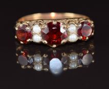 A 9ct gold ring set with round cut garnets and pearls, 3.1g, size T