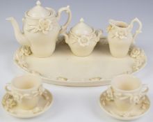 Chinese blanc de chine miniature tea set with applied flower decoration, tallest 10cm
